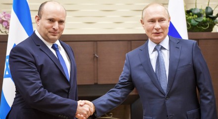 Vladimir Putin and Nafthali Bennet shaking hands